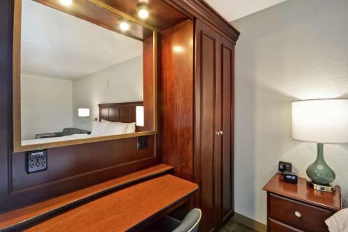 um quarto de hotel com um espelho e uma cama em Hampton Inn Detroit Madison Heights South Troy em Madison Heights