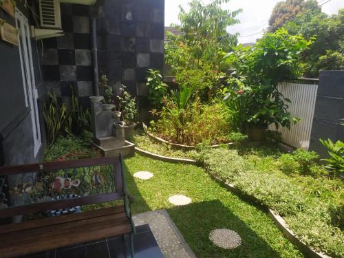 a garden with a bench and some plants at Endah Homestay Syariah in Purwokerto