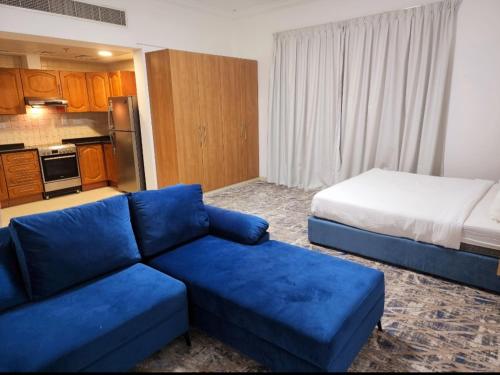 a living room with a blue couch and a bed at Havana Holiday Homes Oud Metha in Dubai