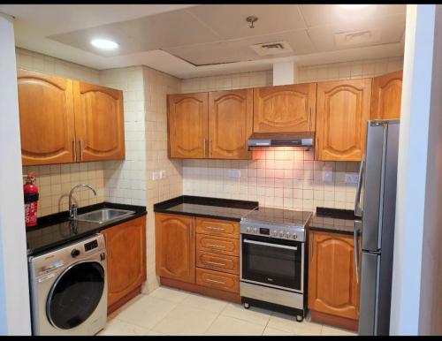 a kitchen with wooden cabinets and a stove top oven at Havana Holiday Homes Oud Metha in Dubai