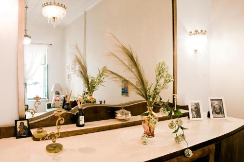 a room with a table with vases and a mirror at Lilian's House in Chania