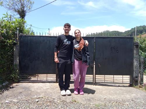 a man and a woman standing in front of a gate at Mount View Cottage in Nuwara Eliya