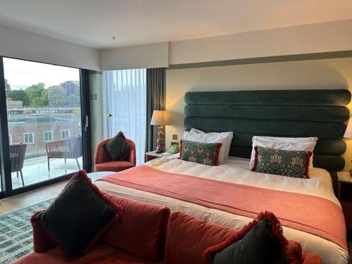 a hotel room with a large bed and a balcony at Hotel Indigo - Exeter by IHG in Exeter
