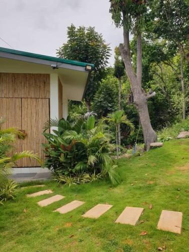 a yard with stepping stones in the grass at The Love Nest - Stylish One Bed House in Chaloklum