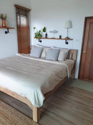 a bedroom with a large bed with pillows on it at The Love Nest - Stylish One Bed House in Chaloklum