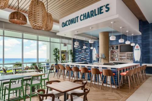 a restaurant with a bar with chairs and tables at Hyatt Place Panama City Beach - Beachfront in Panama City Beach