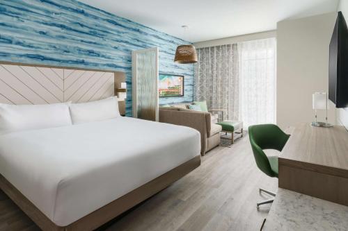 Hyatt Place Panama City Beach - Beachfront في بنما سيتي بيتش: غرفه فندقيه بسرير واريكه