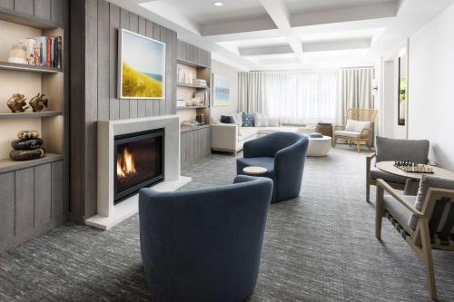 a living room with a fireplace and blue chairs at The Pell, Part of JdV by Hyatt in Middletown