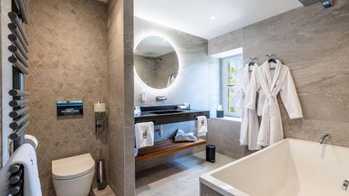 a bathroom with a tub and a sink at Domaine de Dolomieu Hotel & Spa - BW Premier Collection in Dolomieux