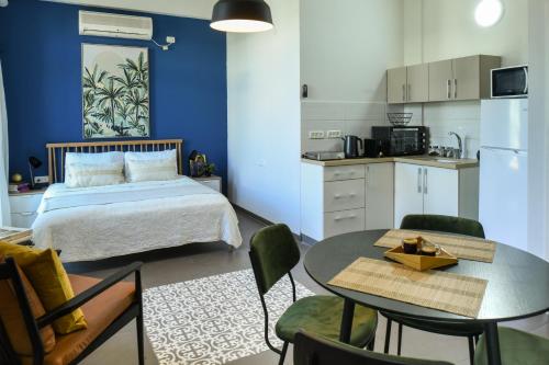 a bedroom with a bed and a table and a kitchen at The Printhouse - Downtown Boutique Apartments by Sea N' Rent in Haifa