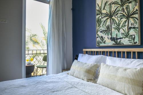 a bedroom with a bed with a view of a balcony at The Printhouse - Downtown Boutique Apartments by Sea N' Rent in Haifa