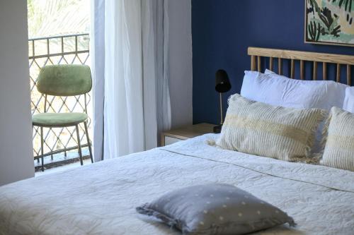 a bedroom with a bed with a chair and a window at The Printhouse - Downtown Boutique Apartments by Sea N' Rent in Haifa
