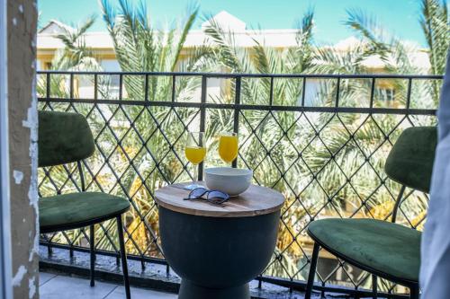 a table with a cup and two glasses on a balcony at The Printhouse - Downtown Boutique Apartments by Sea N' Rent in Haifa
