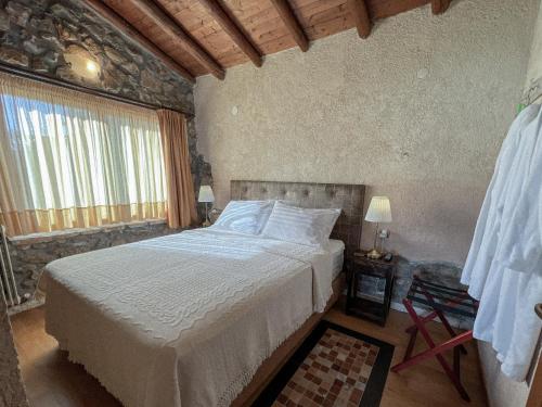 ein Schlafzimmer mit einem großen Bett in einem Zimmer in der Unterkunft The Little Stone House by the Lake in Kastoria