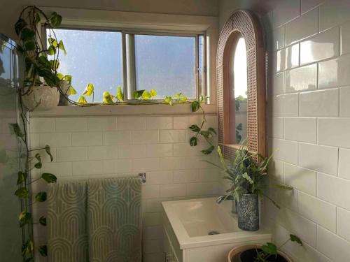 ein Bad mit einer Badewanne, einem Waschbecken und einem Fenster in der Unterkunft Lee's on loftus in Temora