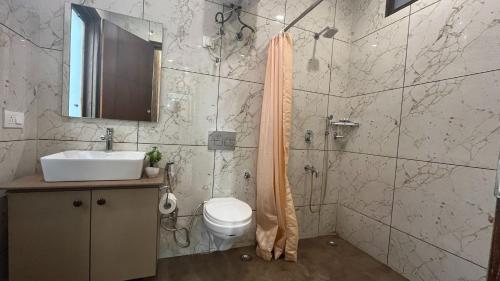ein Bad mit einem WC, einem Waschbecken und einer Dusche in der Unterkunft BluO 1BHK - DLF CyberCity, Balcony, Lift, Parking in Gurgaon
