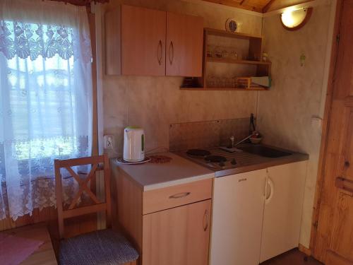 Elle comprend une petite cuisine avec un évier et une fenêtre. dans l'établissement Cozy holiday homes near the beach in Jaros awiec, à Jarosławiec