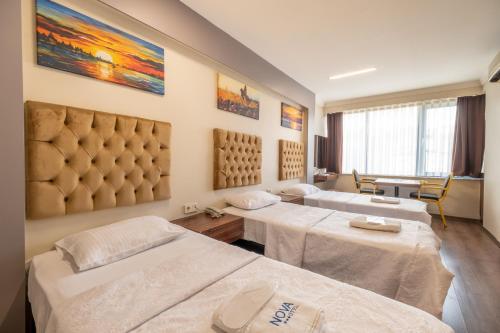 um quarto de hospital com duas camas e uma mesa em Istanbul Nova Hotel em Istambul