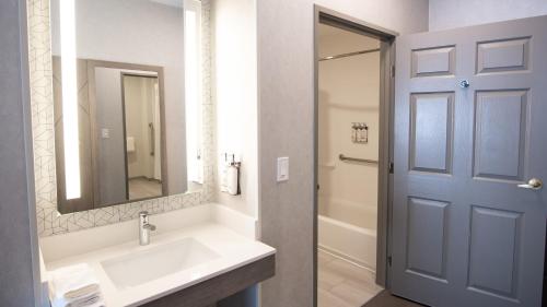 een badkamer met een wastafel en een blauwe deur bij Holiday Inn Express Oakdale, an IHG Hotel in Oakdale