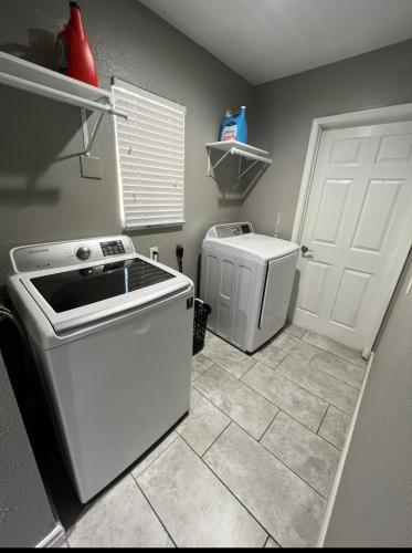 a kitchen with a stove and a washer and dryer at Charming and Cozy Place in Las Vegas