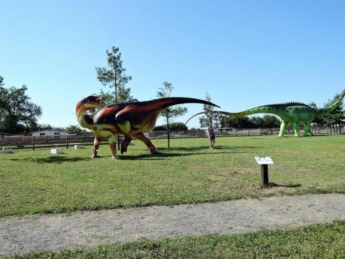 two dinosaur statues of dinosaurs in a field at Pretty bungalow in Wrzosowo with garden in Wrzosowo
