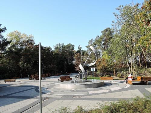 a park with a statue in the middle with benches at Pretty bungalow in Wrzosowo with garden in Wrzosowo