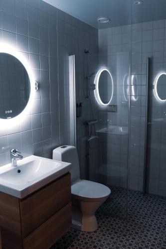 La salle de bains est pourvue de toilettes, d'une douche et d'un lavabo. dans l'établissement Sångbergs Hotell, à Tranemo