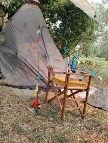 a chair and a tent with a table in front of it at ART CAMP in Néa Michanióna