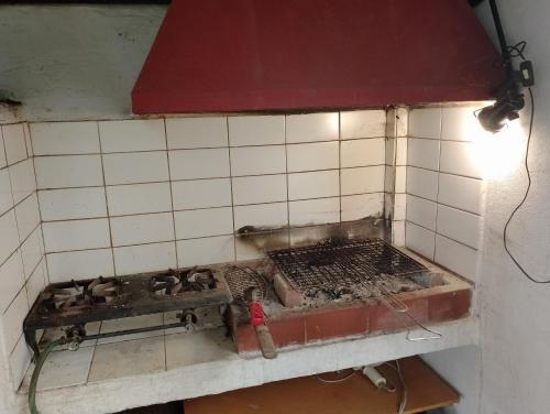 a kitchen with a stove in a tiled wall at ART CAMP in Néa Michanióna