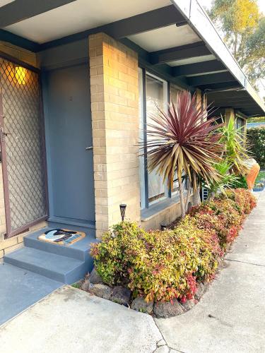 a house with some bushes in front of it at Charming Beach Home in Mornington