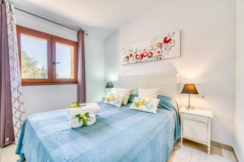 um quarto com uma cama azul e uma janela em El Rafal de Son Alberti em Búger