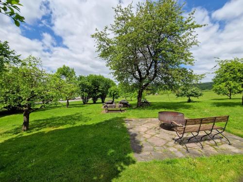 einen Park mit Bänken und Bäumen auf einem Feld in der Unterkunft Kötterhof in Bevern