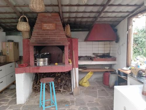 a kitchen with a brick oven with a stool in it at ART CAMP in Néa Michanióna