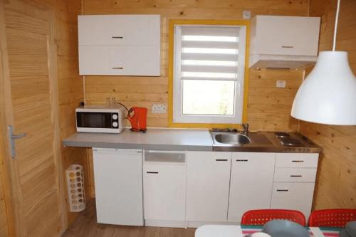 a small kitchen with white cabinets and a microwave at Leisure complex with a swimming pool Jezierzany in Jezierzany