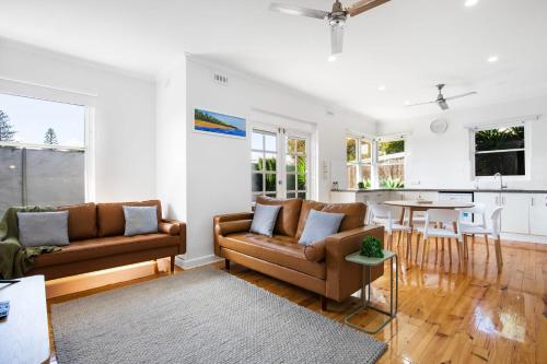 a living room with two couches and a table at Relaxing 3BR Beachside Haven Grange in Grange
