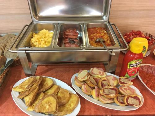 two plates of food on a table with breakfast foods at City Hotel Siófok in Siófok