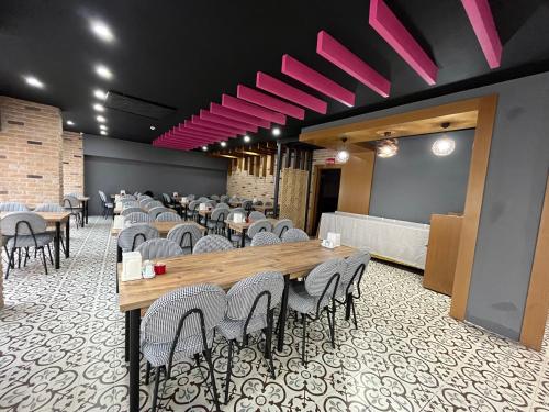 una sala da pranzo con tavoli, sedie e luci rosa di Nobel Boutique Hotel a Selçuk