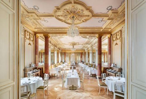 uma sala de jantar com mesas brancas e um lustre em One Shot Palácio Cedofeita no Porto