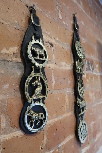 a black and gold object hanging on a brick wall at The Old Pantry at Hill Farm in Penley
