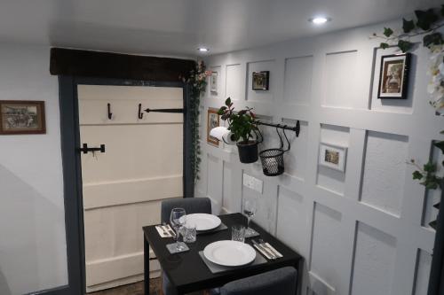 a dining room with a table with two plates on it at The Old Pantry at Hill Farm in Penley