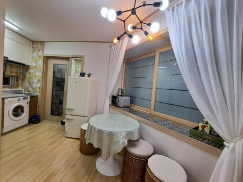 a small kitchen with a table and a window at Dongpirang Purple House 2 in Tongyeong