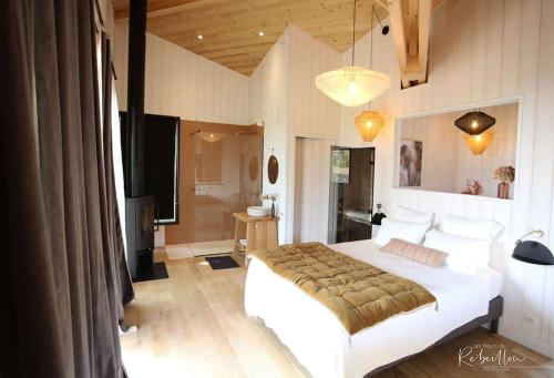 Tempat tidur dalam kamar di les Hauts de Rébeillou - Cabane Spa