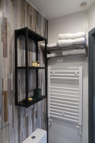 a bathroom with a toilet and a shelf above a toilet at The Old Pantry at Hill Farm in Penley