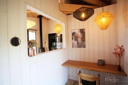 a room with a counter and two lights and a mirror at les Hauts de Rébeillou - Cabane Spa in Flourens