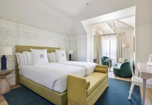 una habitación de hotel con una cama grande y una silla en One Shot Palácio Cedofeita en Oporto