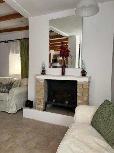 a living room with a fireplace and a mirror at Vagelis house - Gardelades in Corfu Town
