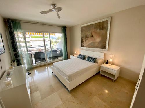 1 dormitorio con 1 cama y una pintura en la pared en Apartamento con vistas y terraza en Guadalmina Marbella en Marbella
