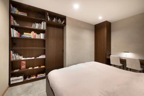 ein Schlafzimmer mit einem Bett und einem Bücherregal in der Unterkunft Nuit Blanche in Oud-Heverlee