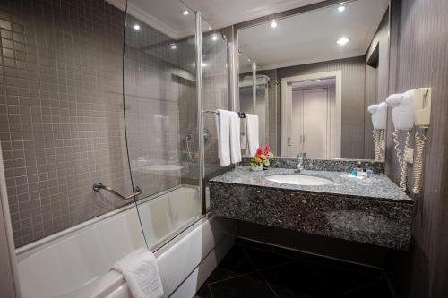 a bathroom with a sink and a shower at Buyukhanli Park Hotel in Ankara