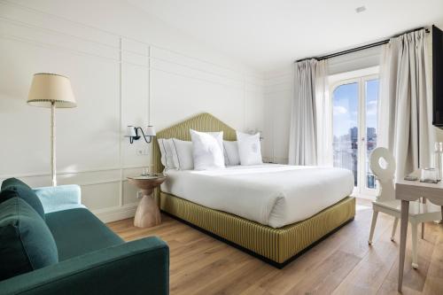 a bedroom with a bed and a couch and a window at One Shot Palácio Cedofeita in Porto